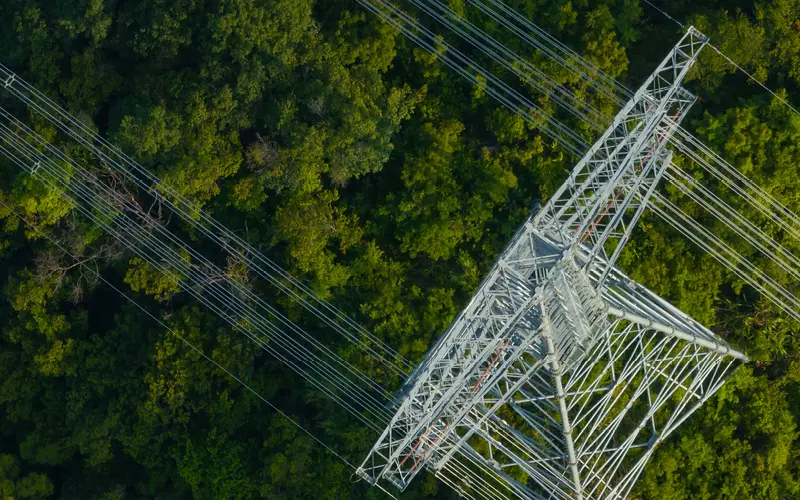Transmission tower with blue sky and sun