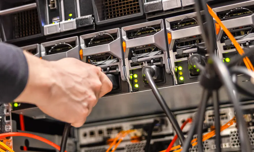 Close up of male technician plugging in computer cable
