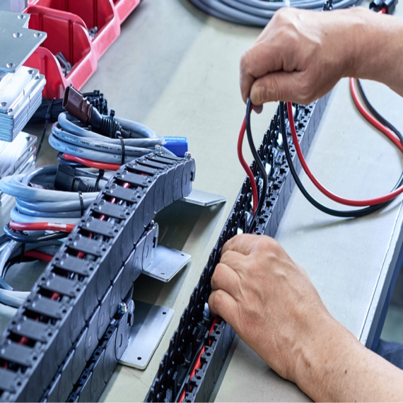 Custom HELU drag chain system guiding cables inside a roadside assistance vehicle storage compartment