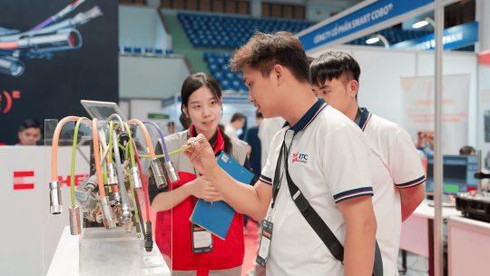 Sales trò chuyện với khách tại gian hàng