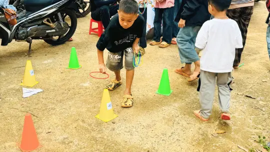 The children are playing a ring-toss game