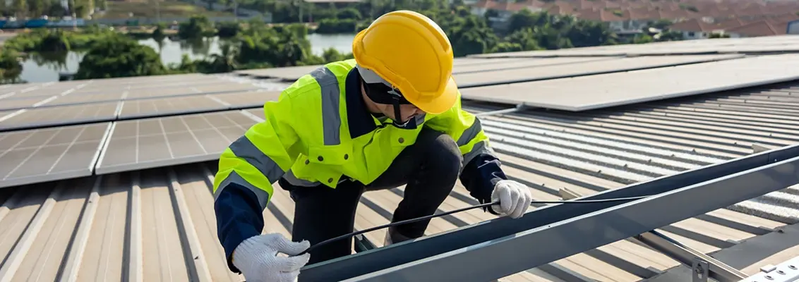 Man working on a photovoltaic system on the roof of a house