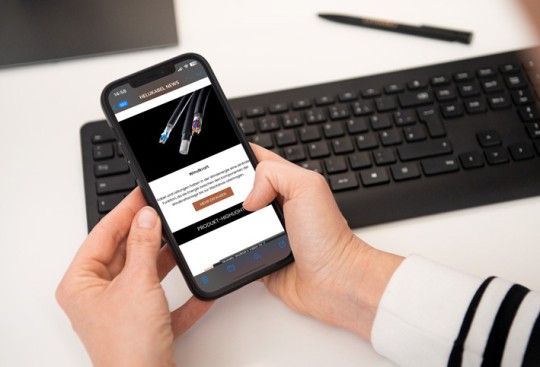 Person reading HELUKABEL Newsletter on a mobile phone