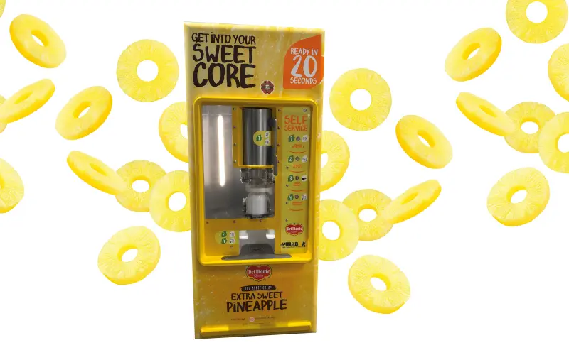 Pineapple peeler in front of flying pineapple slices