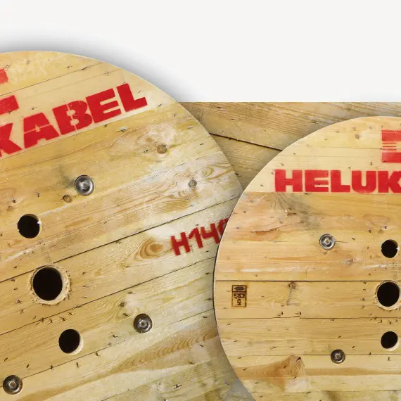 A close-up of two cable drums printed with the iconic red HELU logo.