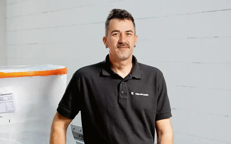 Klaus Münchenbach standing in front of a pallet with cable