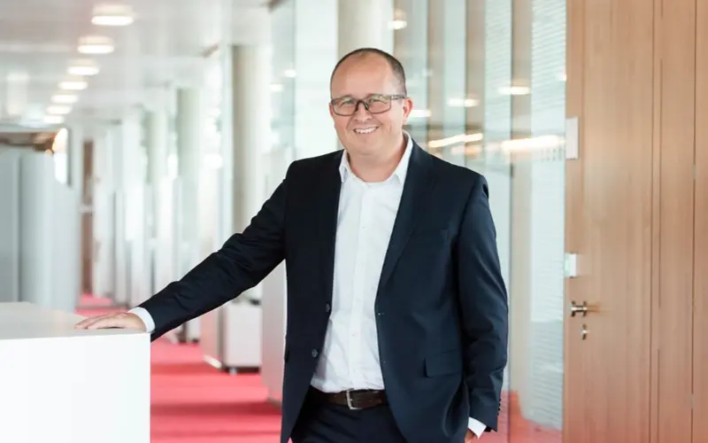 Markus Schöck standing and leaning against a cabinet