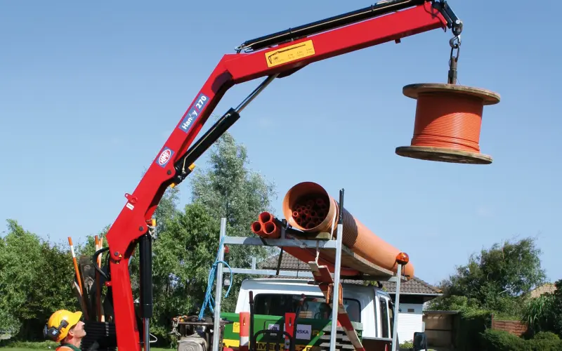 Mobile crane unloading a cable drum