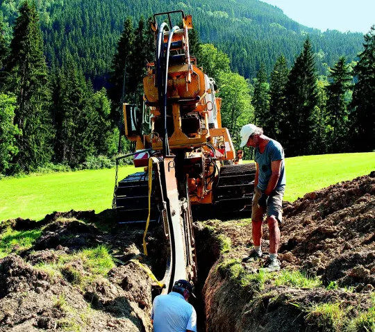 Graafmachine legt kabel in de natuur