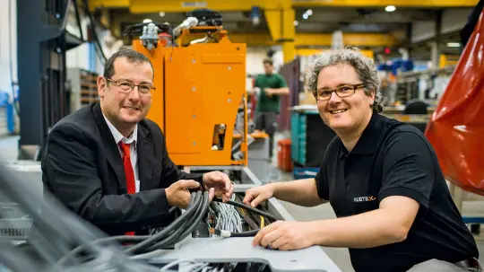 Sascha Link and Stephan Hohmann look at a cable