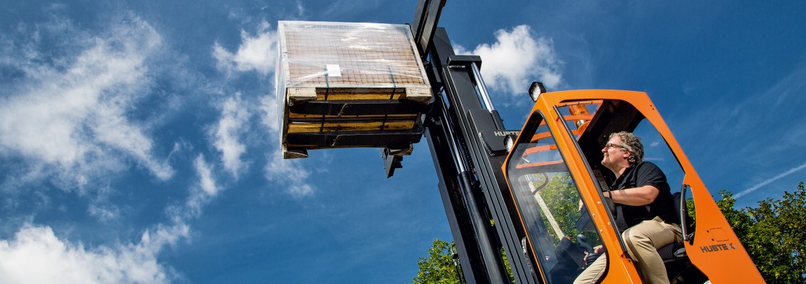 A man carrying a pallet with goods on it with a forklift