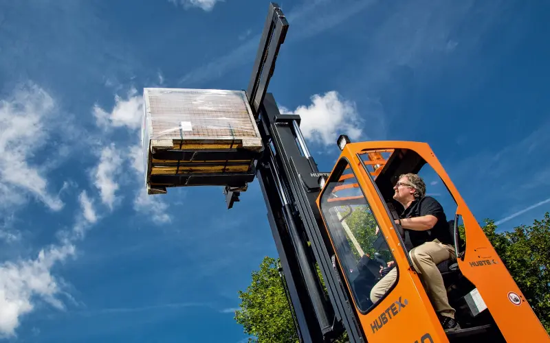 A man carrying a pallet with goods on it with a forklift