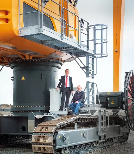 two men sitting on the excavator