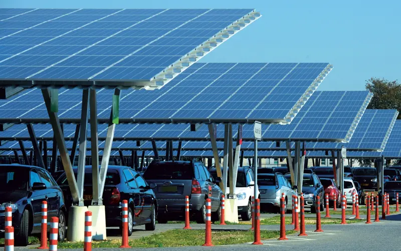 Carports with solar panels under which are parked cars