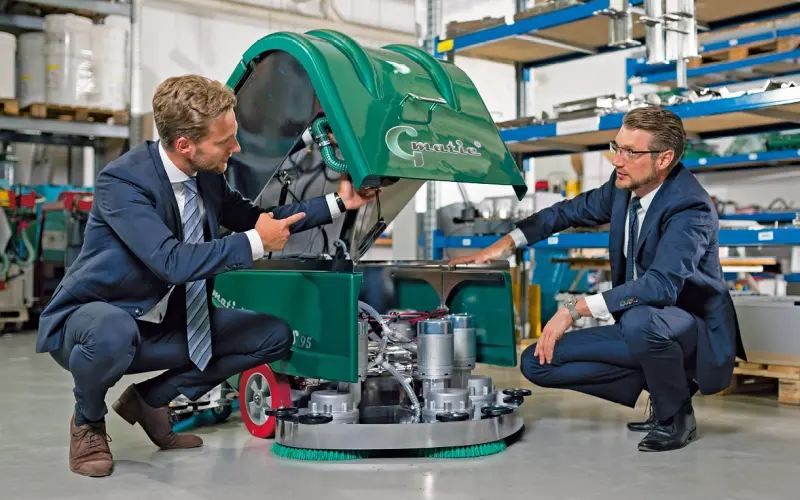 Moritz Gansow and Heiko Müller checking a floor cleaning machine