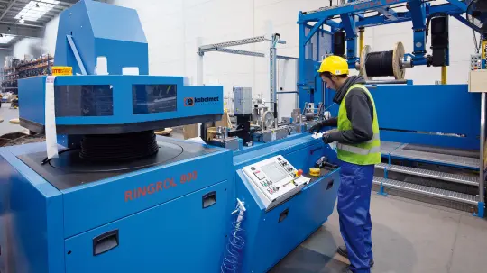 Mitarbeiter bedient Kabelzuschneideanlage